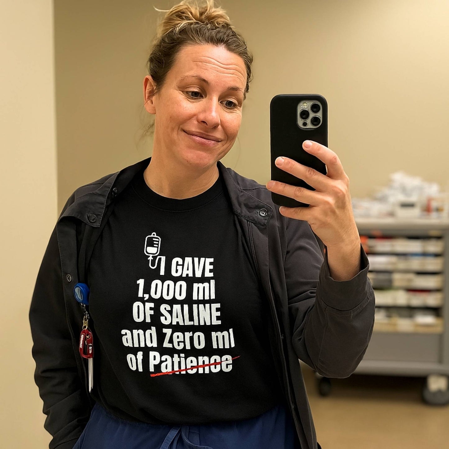 Funny ER nurse gift — cotton nurse t-shirt reading "1,000ml of saline. 0ml of patience"